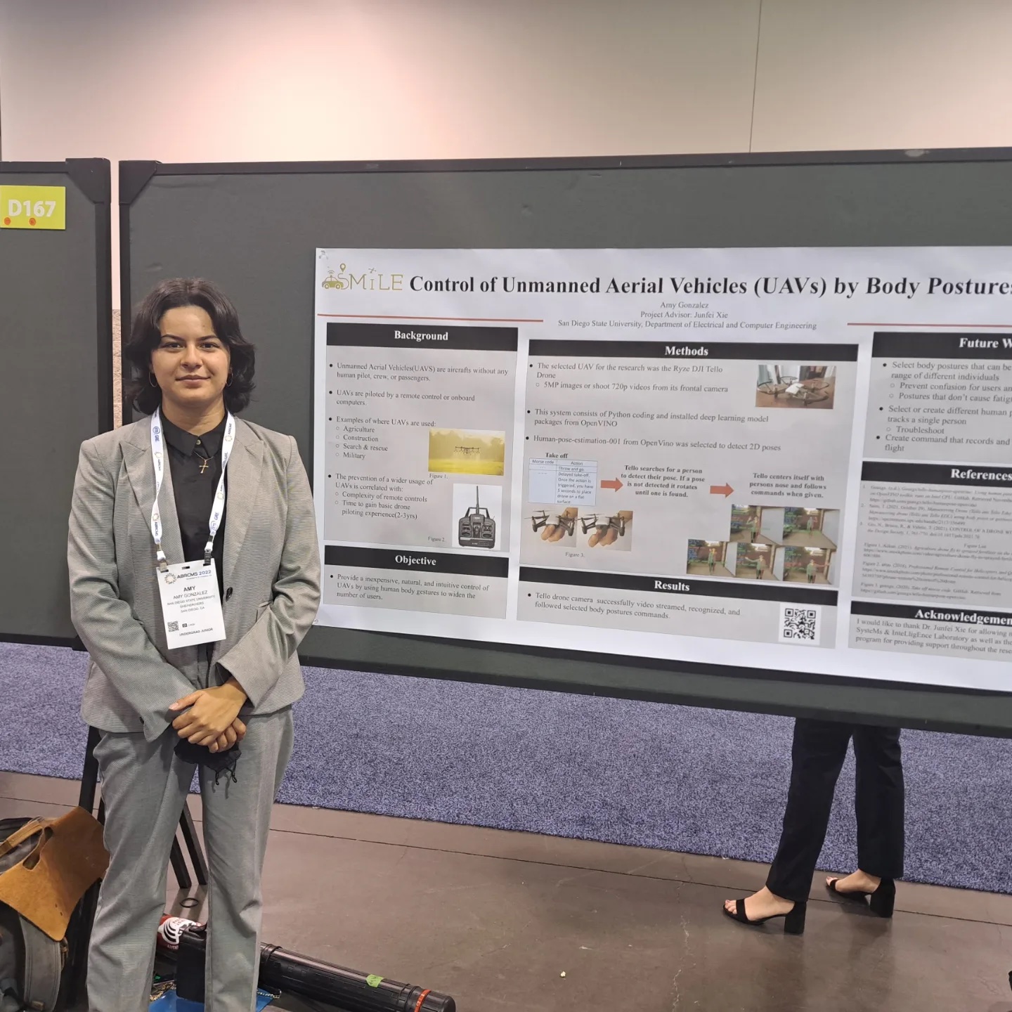 Scholar presents poster at ABRCMS Anaheim. Wearing a great pant suit and wears a conference name badge around their neck